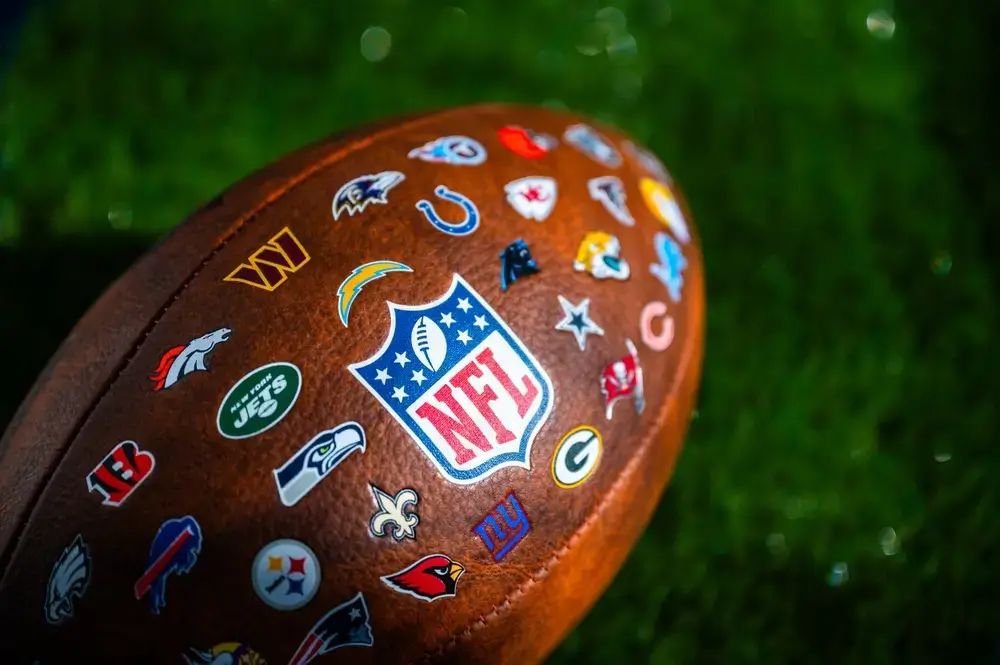 Foto eines Balles mit Stickern der NFL Mannschaften.