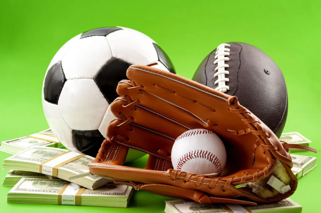 Ball von einem Fußball, Rugby-Ball und einem Baseball im Handschuh auf einen Haufen Geldscheinen